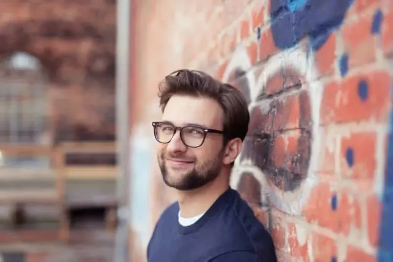 Mann mit Brille laechelt