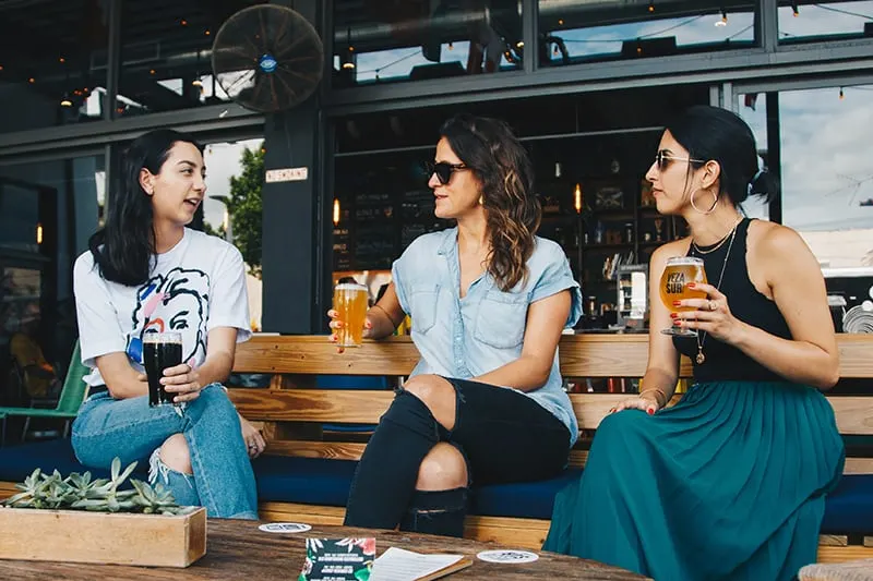 Drei Frauen trinken Bier, während sie zusammen sitzen