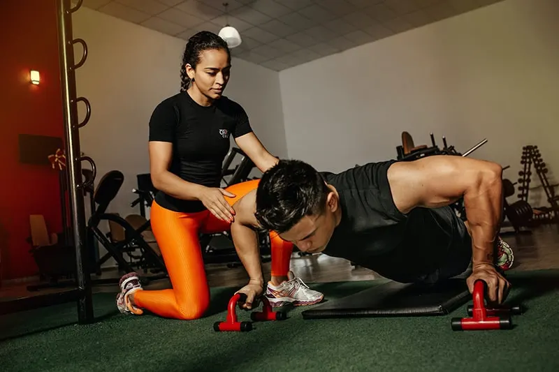 Ein Mann und eine Frau trainieren zusammen im Fitnessstudio