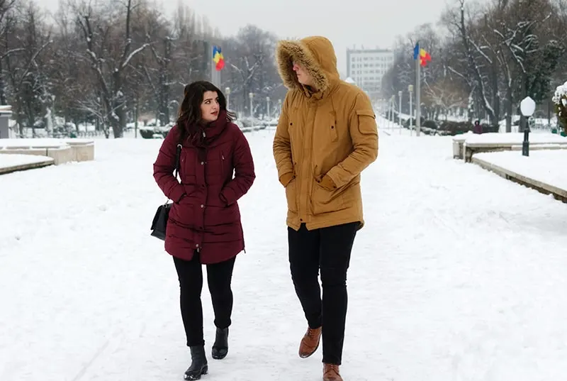 Ein Mann und eine Frau unterhalten sich beim Gehen auf dem Schnee