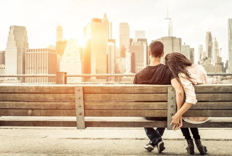 Ein Paar sitzt auf einer Bank und beobachtet die Stadt