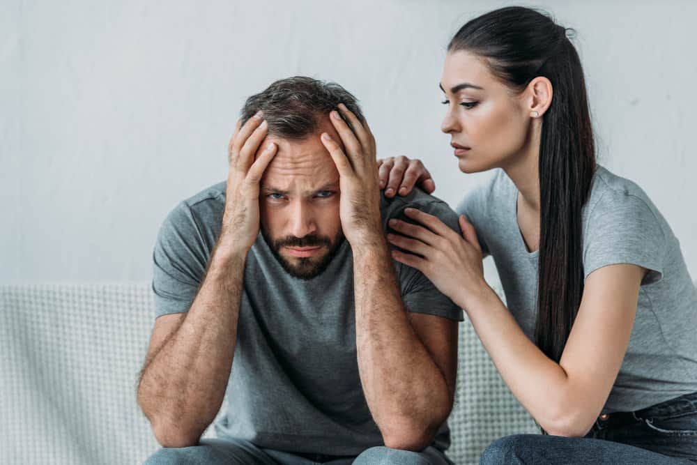 Eine Frau sympathisiert und tröstet ihren depressiven Mann