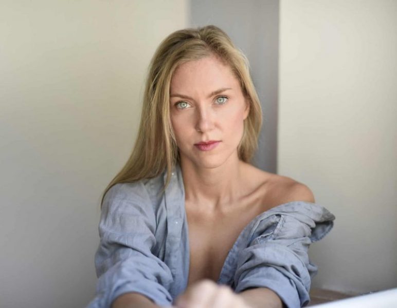 Eine ernsthafte Blondine sitzt in einem Jeanshemd für Männer