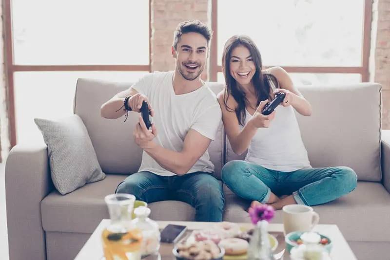 Mann und Frau spielen mit Playstation