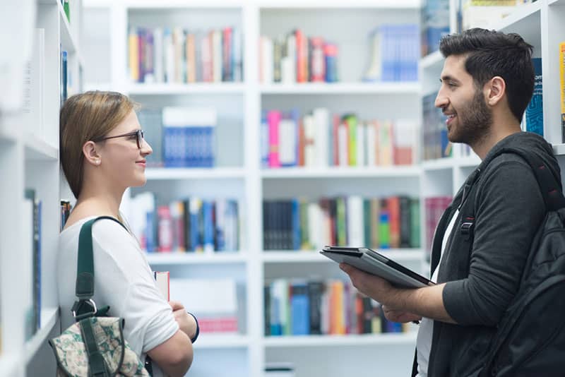 Frau und Mann schauen sich in der Bibliothek an