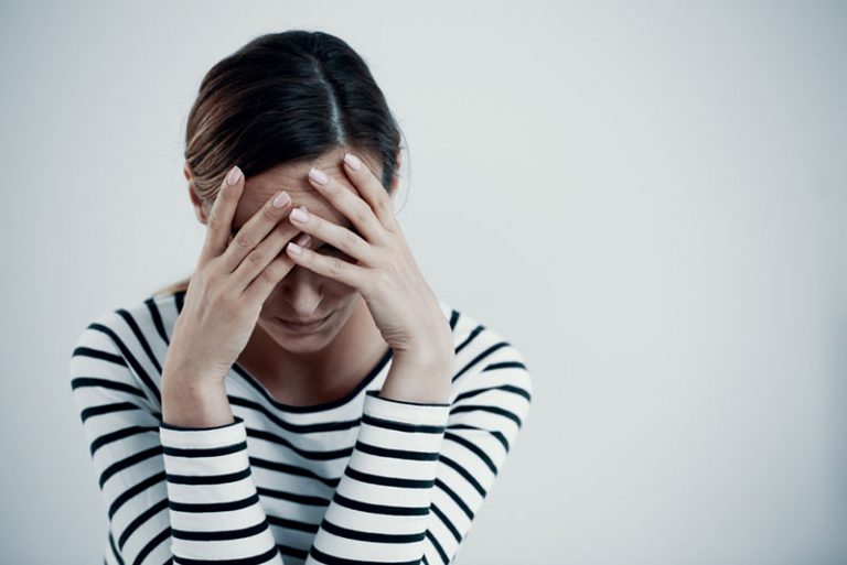 depressive Frau mit Händen im Gesicht