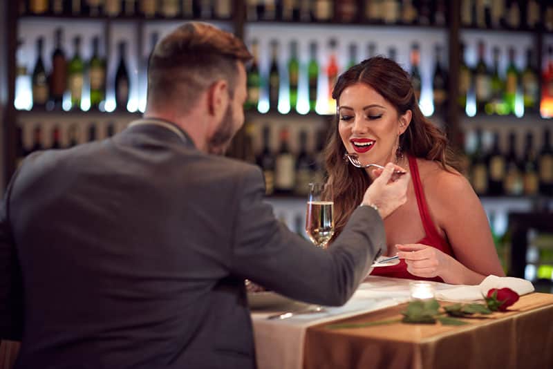 Mann füttert Frau im Restaurant