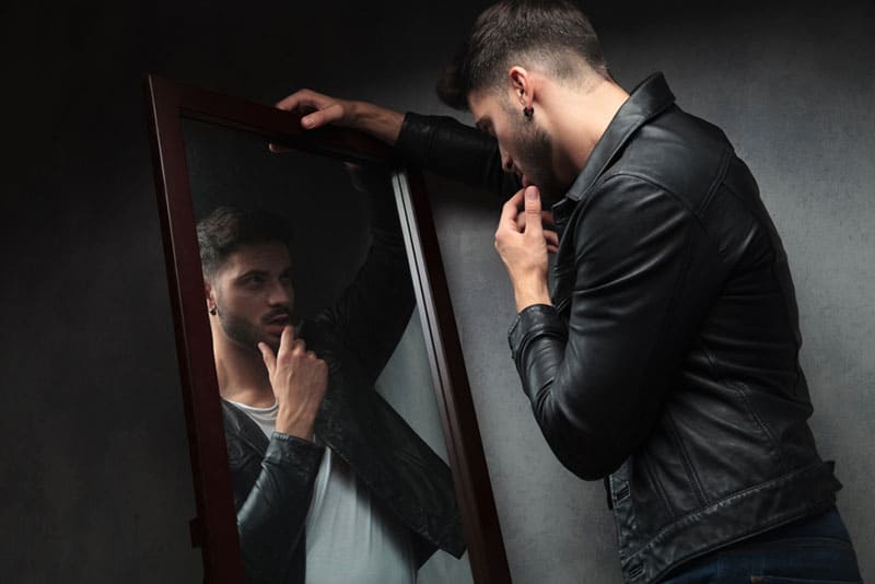 Mann schaut auf Spiegel