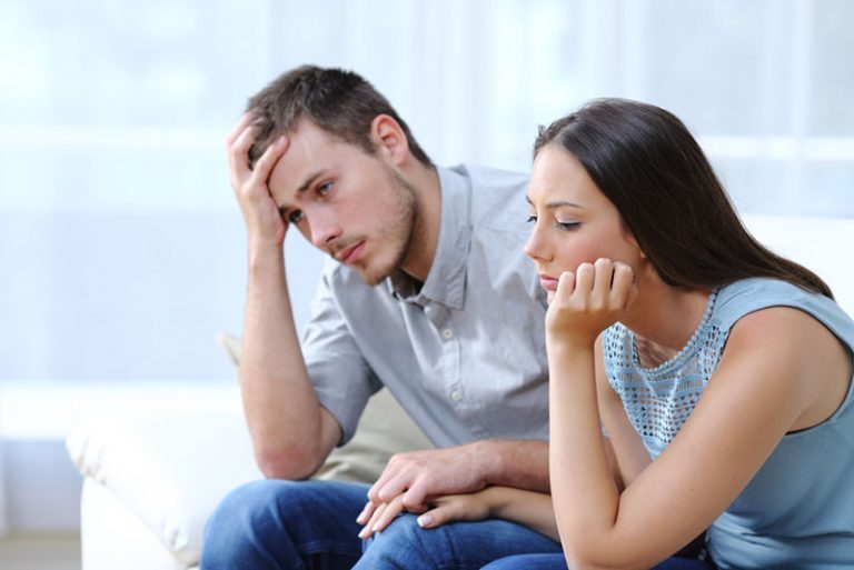 sad couple sitting and holding hands