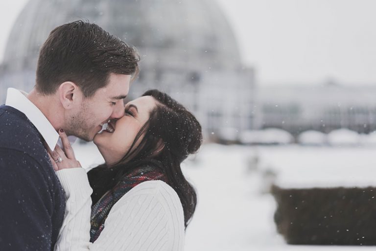 ein glückliches Paar, das sich im Schnee küsst
