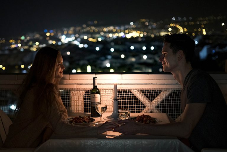 Ein Mann und eine Frau beim romantischen Abendessen auf dem Dach