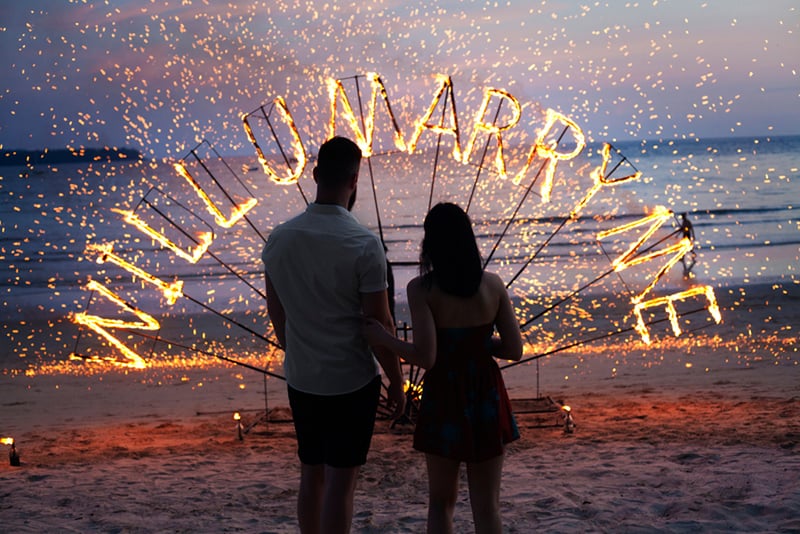 Ein Mann, der eine Ehe mit einer Frau vorschlägt, während er am Strand vor der Überraschung des Vorschlags steht