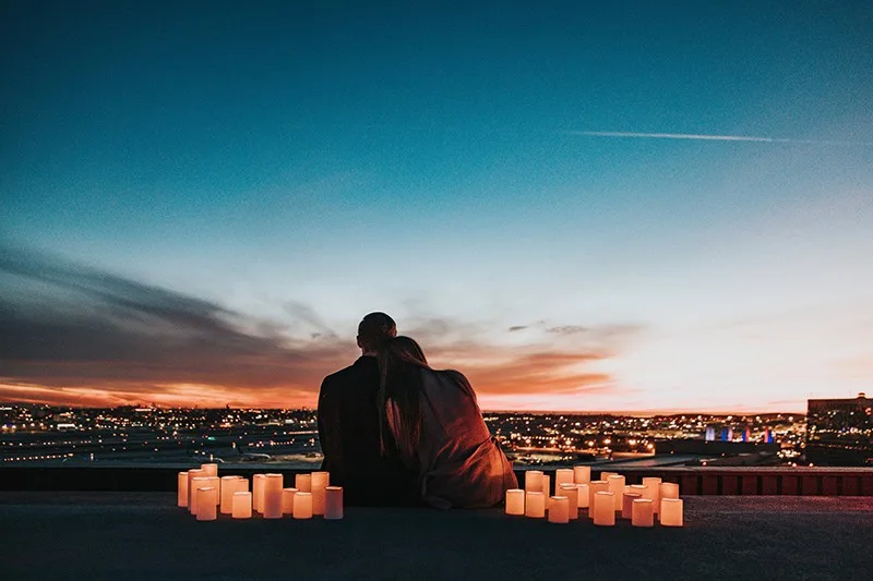 Ein Paar sitzt auf dem Dach, umgeben von Kerzen