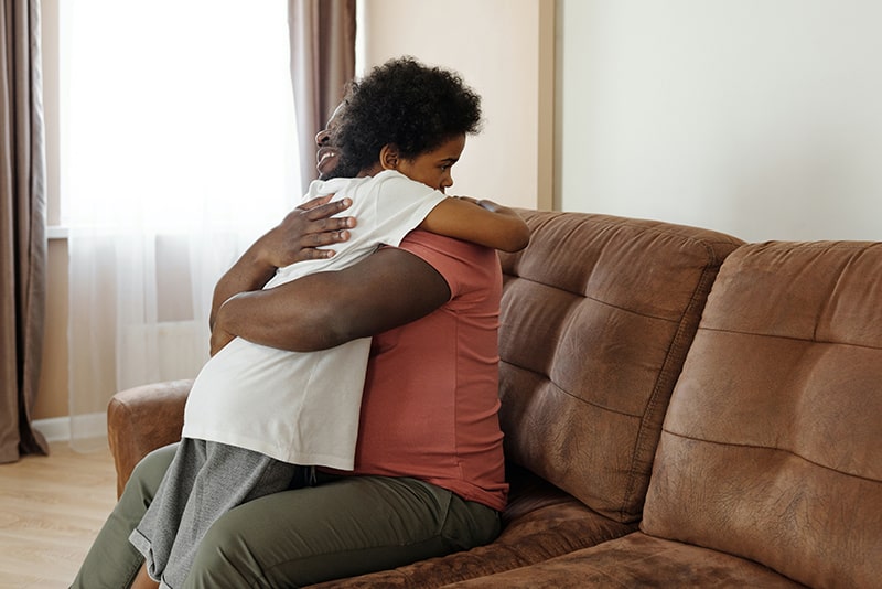 Ein Vater umarmte seinen Sohn, während er auf dem Sofa saß