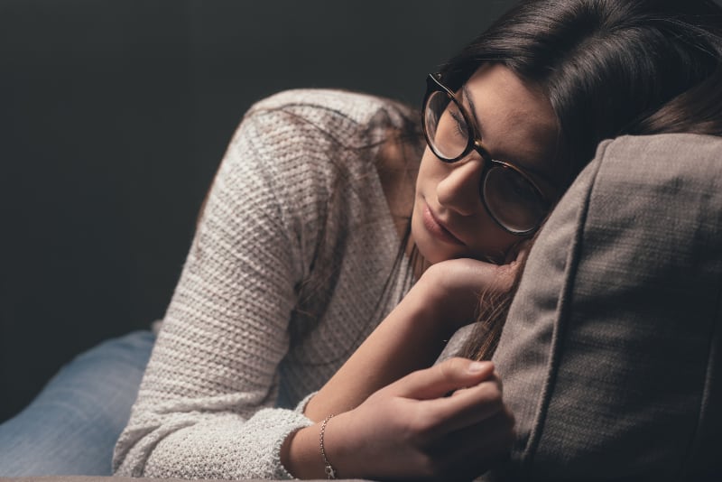 ein depressives Mädchen sitzt auf der Couch