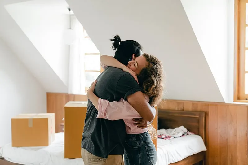 Ein liebevolles Paar umarmt sich fest im Schlafzimmer