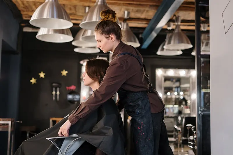 eine Frau bekommt einen Haarschnitt in einem Friseursalon