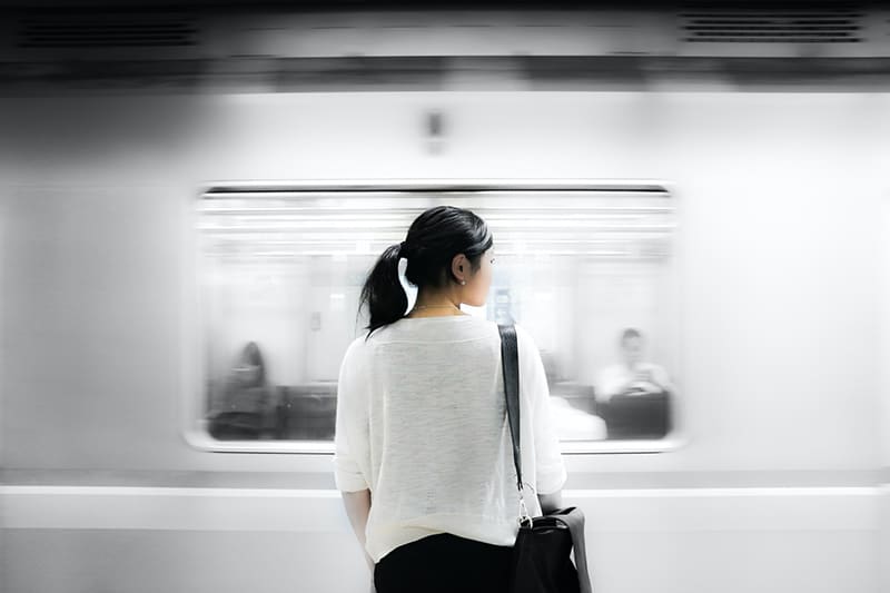 eine Frau, die in der Nähe eines Zuges in einer U-Bahn steht