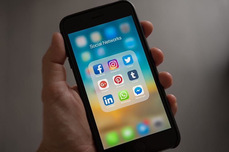 eine Person, die ein Smartphone in der Hand hält und Apps von sozialen Netzwerken überprüft