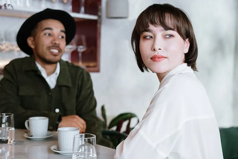 eine nachdenkliche Frau, die mit einem Mann im Café sitzt