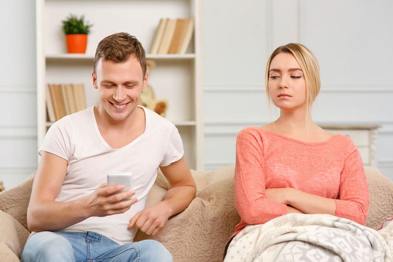 verdächtige Frau, die Mann Telefon ansieht