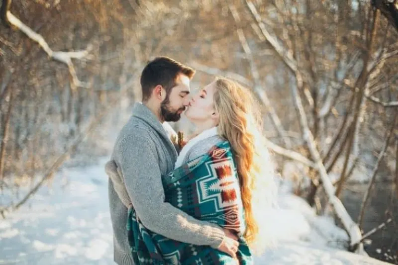 Ein schönes verliebtes Paar genießt eine schneebedeckte Idylle