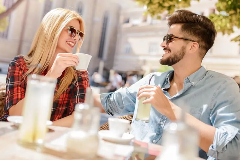 Ein Mann und eine Frau sitzen in einem Café und genießen Kaffee und Limonade bei einem Date