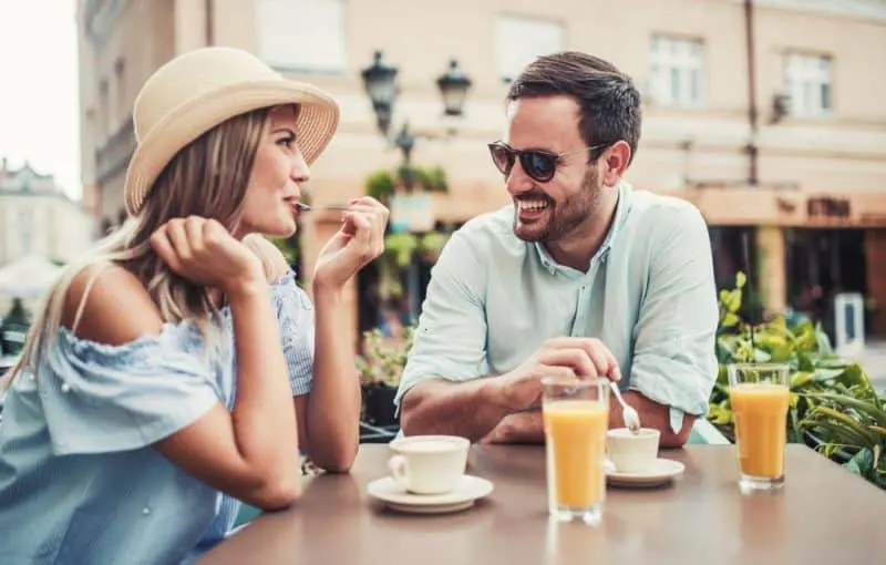 Eine Frau und ein Mann flirten über ein Café