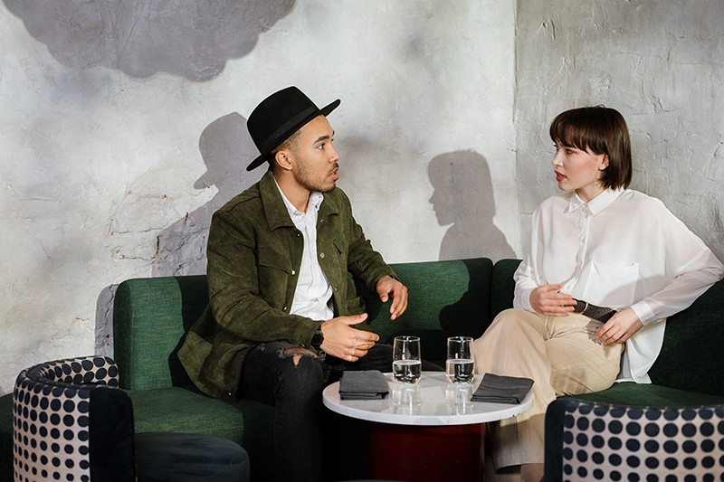 Ein Mann, der nervös aussieht und während eines Dates mit einer Frau spricht