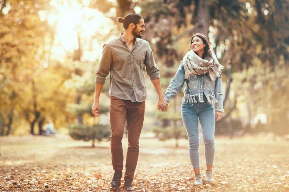 Ein Mann und eine Frau gehen Händchen haltend