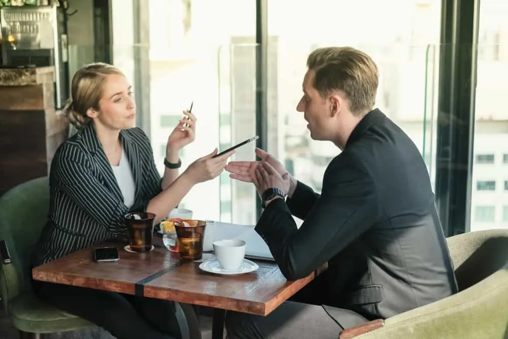 Ein Mann und eine Frau sitzen an einem Tisch und streiten sich