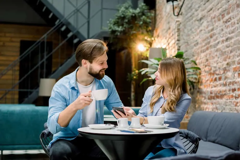 Ein Mann und eine Frau sitzen, trinken Kaffee und reden