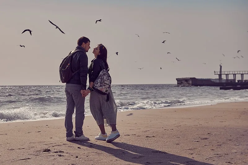 Ein Mann und eine Frau stehen am Strand und wollen sich küssen