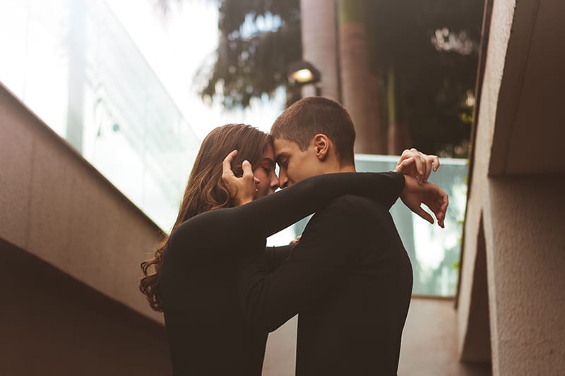 Ein Mann und eine Frau wollen sich küssen, während sie draußen stehen