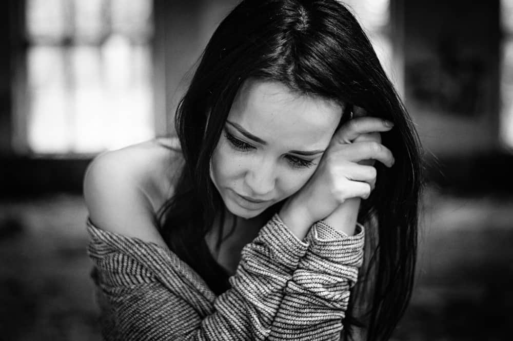 Ein depressives Mädchen hockt und weint