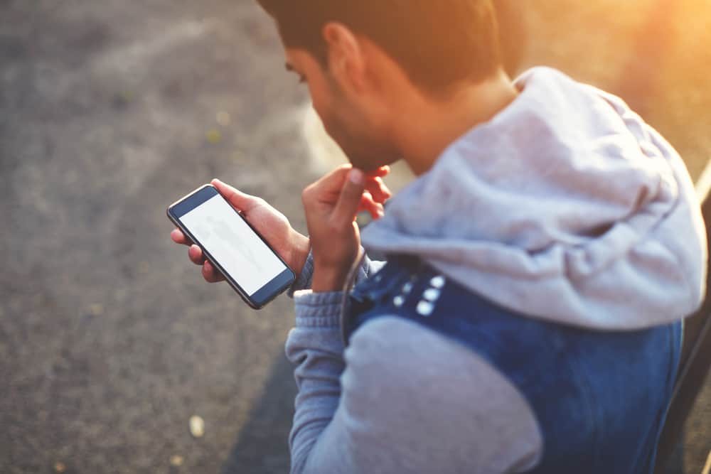 Ein dunkelhäutiger Mann benutzt ein Handy