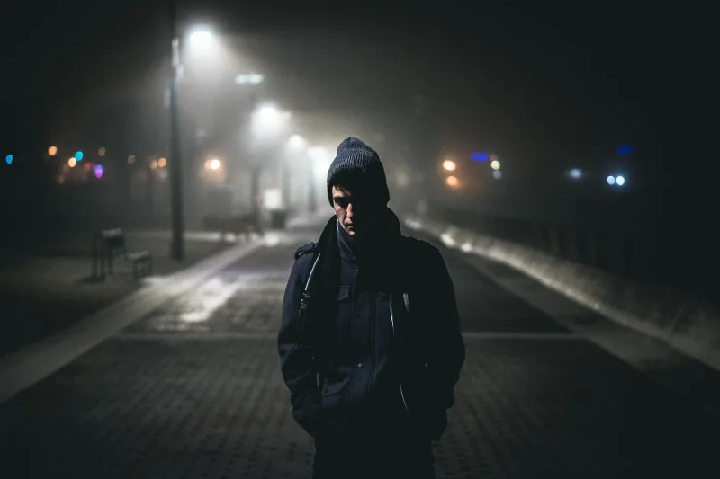 Ein einsamer Mann geht nachts die Straße entlang