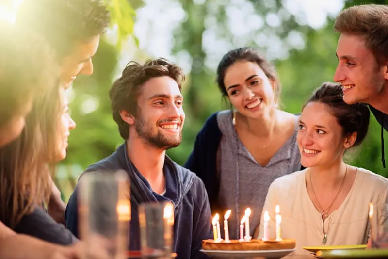 Eine Gruppe junger Leute versammelte sich auf einer Terrasse, um den Geburtstag eines ihrer Freunde zu feiern