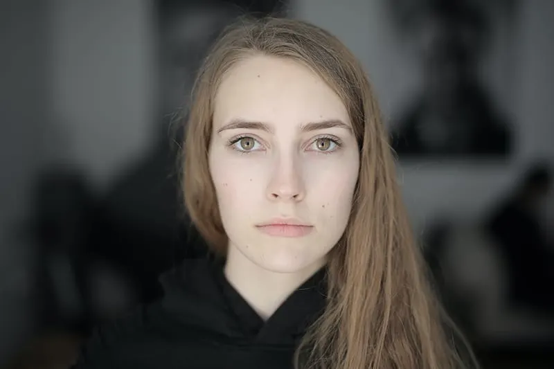 eine ernsthafte Frau, die einen schwarzen Hoodie trägt