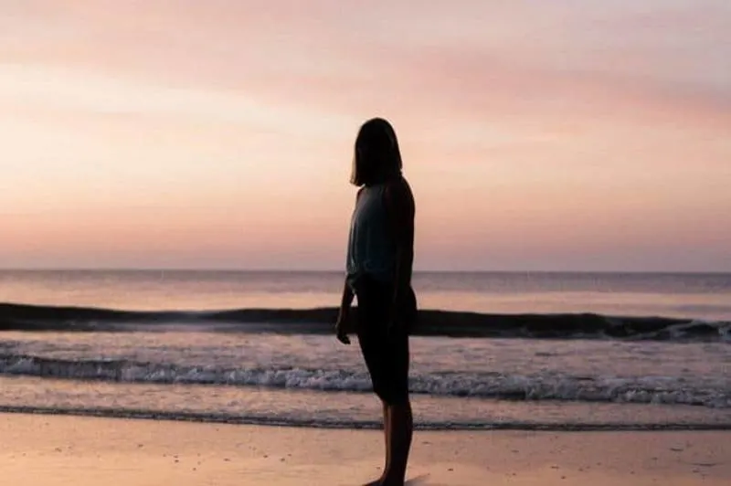 ein einsames Mädchen am Strand stehen