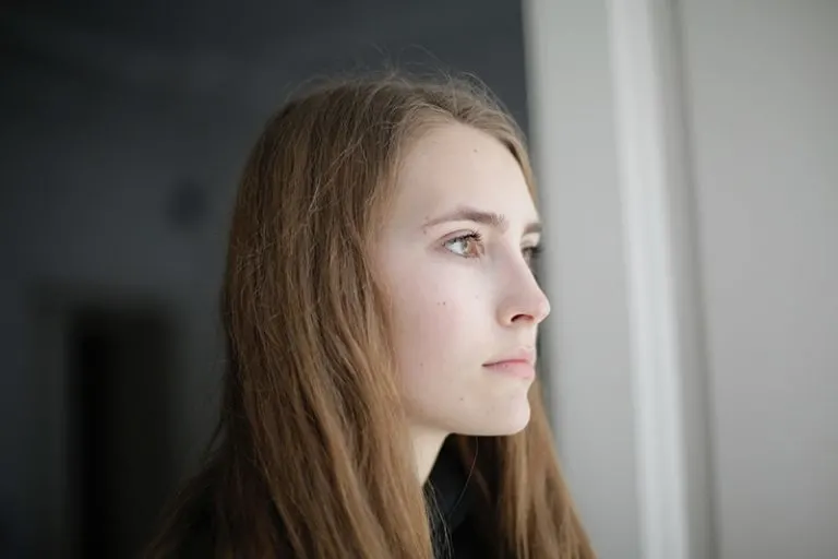 eine nachdenkliche Frau, die im Haus steht