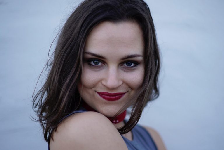 eine lächelnde Frau mit rotem Lippenstift