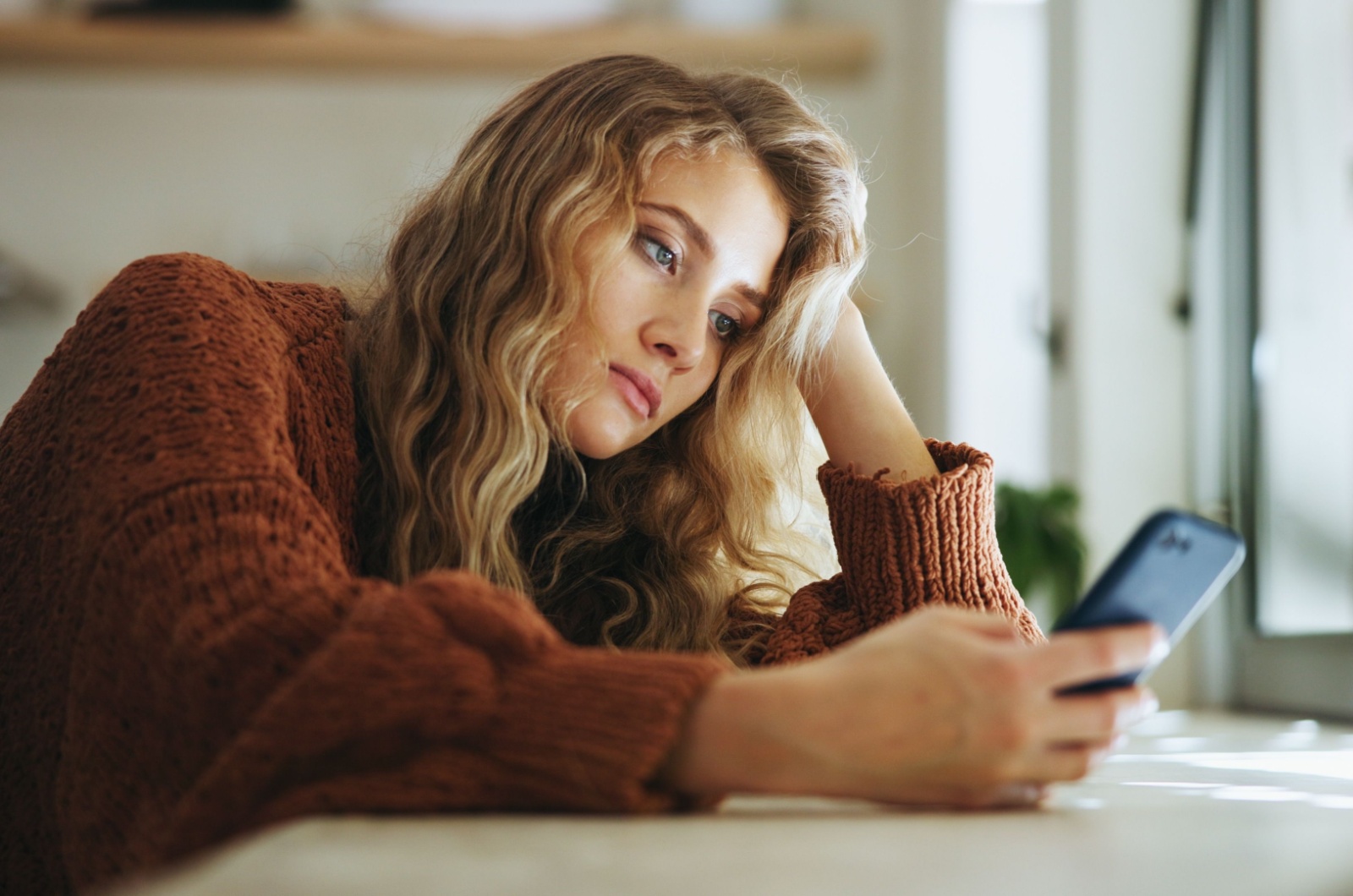 Traurige Frau schaut auf ihr Telefon