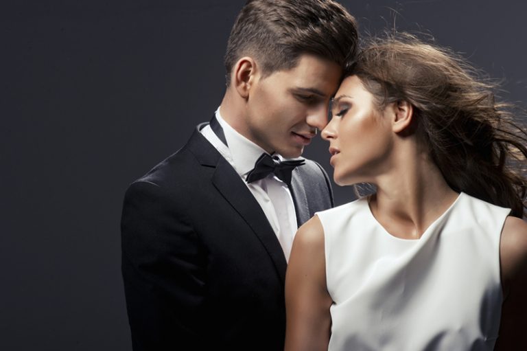 ein elegant gekleidetes Paar, das sich gerade küssen will