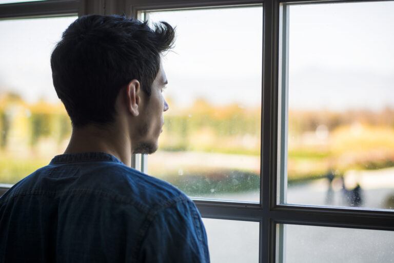 Mann, der durch das Fenster schaut