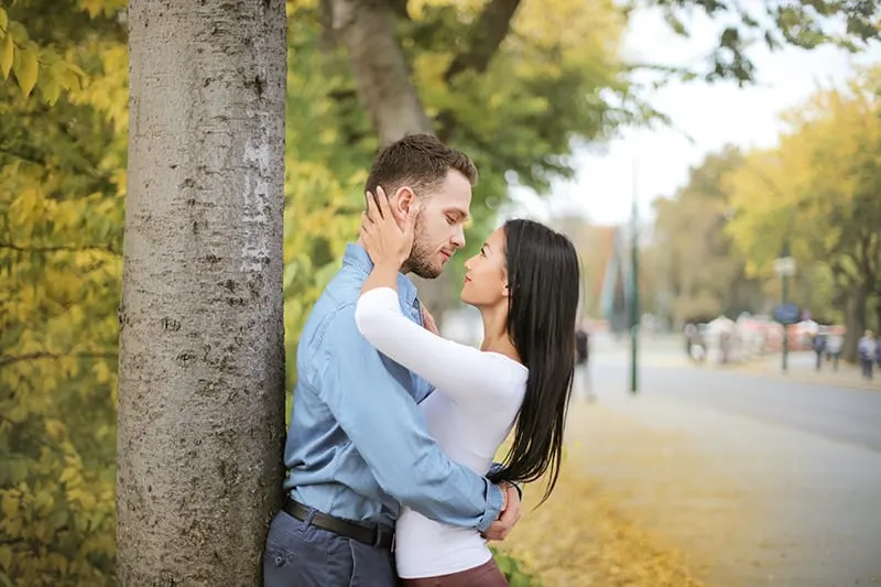 Ein Mann umarmt seine Freundin, während er sich ansieht