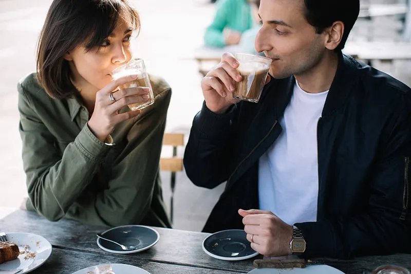 ein Mann und eine Frau, die sich beim Kaffeetrinken ansehen