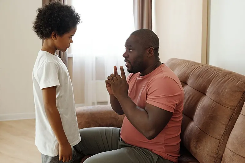 Ein Vater spricht mit seinem Sohn, während er mit den Händen gestikuliert