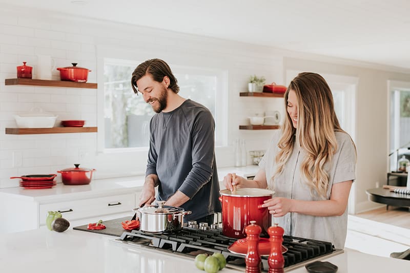 ein glückliches Paar, das gemeinsam in der Küche Essen zubereitet