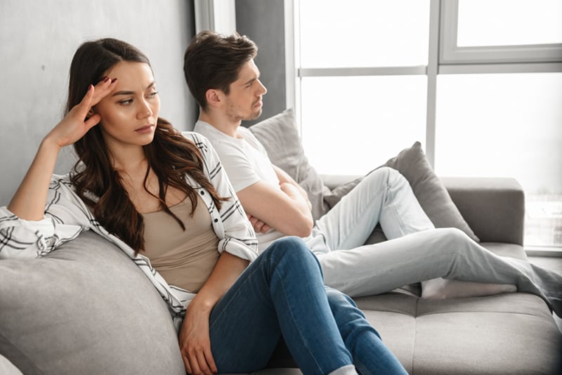 ein verärgertes Paar, das nach einem Streit auf der Couch sitzt